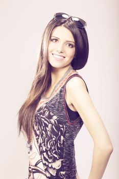 Happy young brunette woman with sun glasses against white background, Fashion portrait