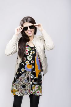 Happy young brunette woman with sun glasses against white background, Fashion portrait