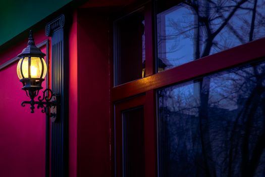 Vintage street lamp at the evening with reflection in window