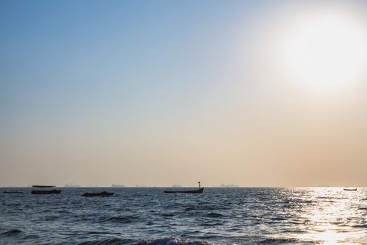 Fishermans boats at Arabian sea. Cargo ships on the background