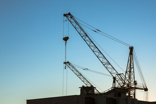 Construction crane on clear blue sky background