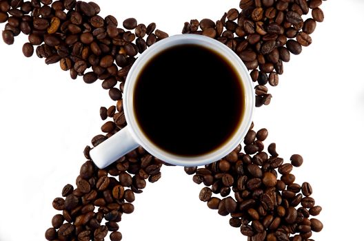 White cup with coffee and trowel of coffee beans