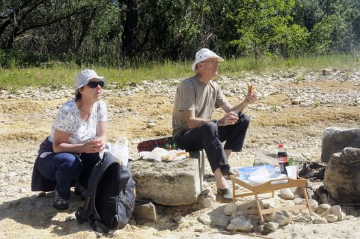 Picnic in walk for friends who have decided to enjoy the first days of spring in the French Cevennes region along the Gardon River in the department of Gard.