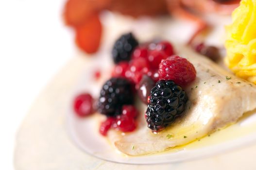 Macro close up of grilled sea with blackberry, berry and potatoes