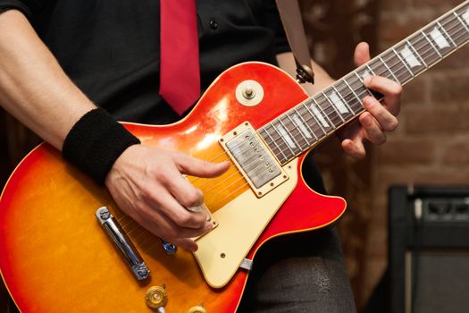 Musician performs solo on electric guitar. Close-up, shallow depth of field