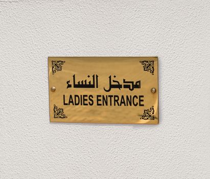 Ladies entrance sign to a Mosque, on a white wall