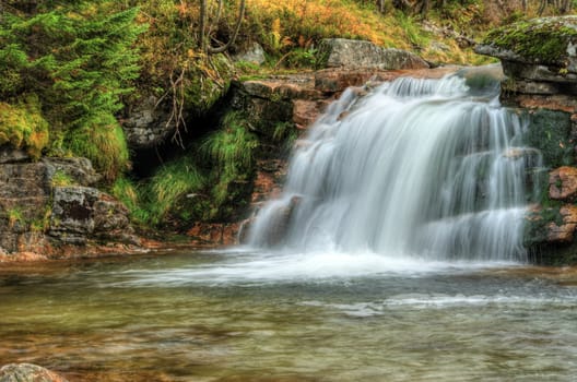 Amazing waterfall in a wooded mountainous landscape 