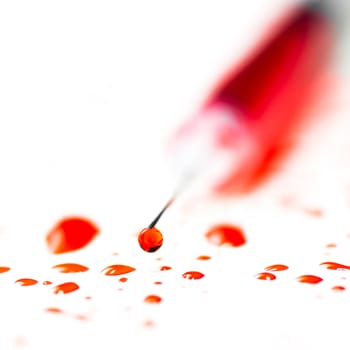 Hypodermic syringe with blood on a white background