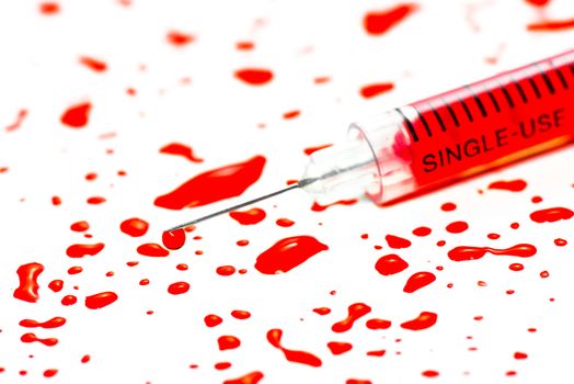 Closeup hypodermic syringe with blood on a white background