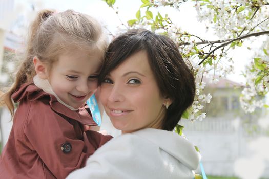 Happy mother and baby girl in spring garden