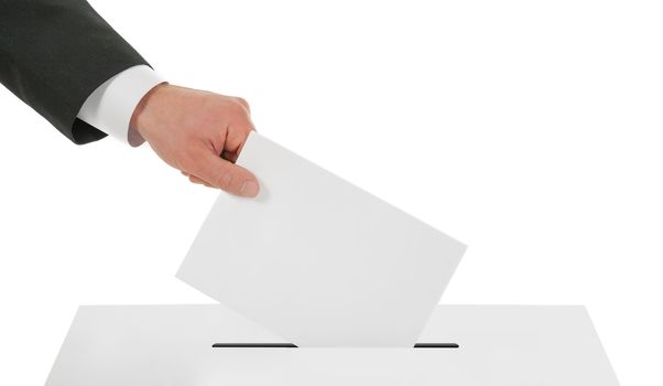 Man's hand down the ballot in the ballot box. Isolated on white