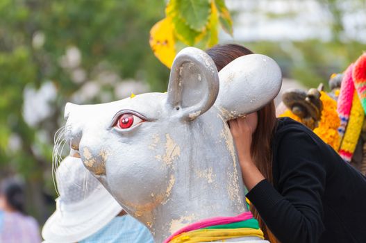 Girl make whisper and wish on rat statue in wat thai