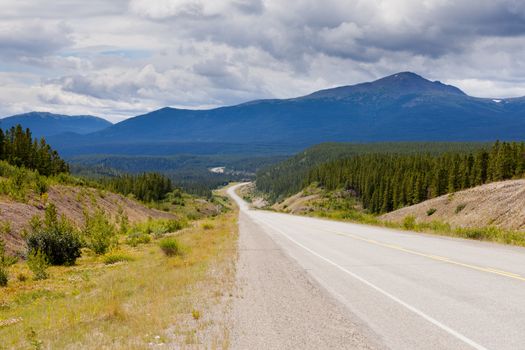 Endless empty road of Alaska Highway, Alcan, crossing wide open expanse boreal forest taiga landscape west of Watson Lake, Yukon Territory, Canada