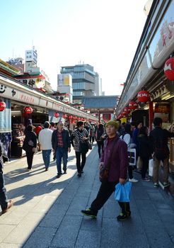 TOKYO, JAPAN - NOV 21 : Nakamise shopping street in Asakusa, Tokyo on 21 November 2013. The busy arcade connects Senso-ji Temple to it's outer gate Kaminarimon, which can just be seen in the distance. 