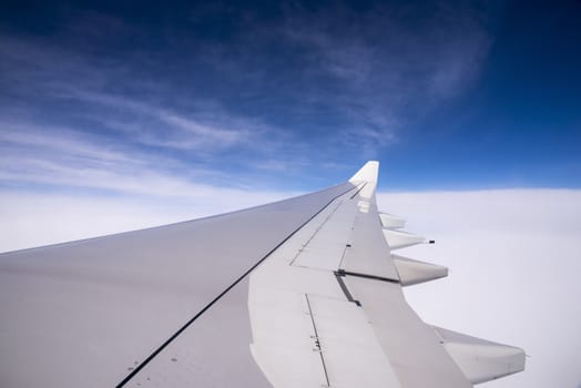 Wing of an airplane flying above the clouds