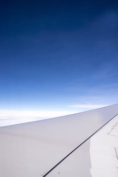 Wing of an airplane flying above the clouds