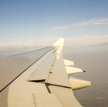 Wing of an airplane flying above the clouds