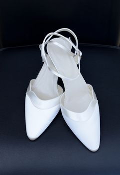 Brides white shoes closeup on black background