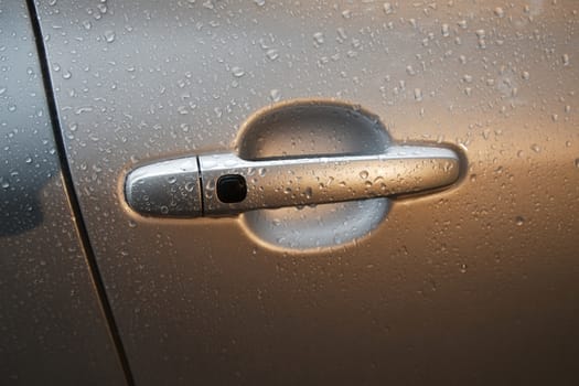 Door handle of a car in rain