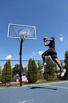 Young basketball player drives to the hoop with some fancy moves.