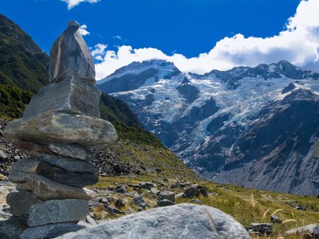 Rock cairn in Hooker Valley on a trail leading to Aoraki, Mount Cook, highest peak of Southern Alps an icon of New Zealand partially covered in clouds