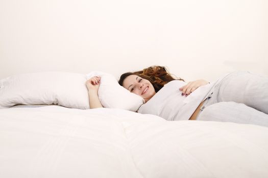 A young adult Woman relaxing on the Bed.