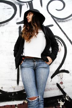 A young woman leaning on a wall.