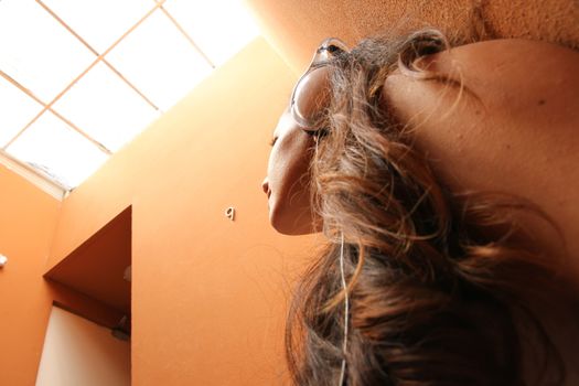 A young woman listening to melancholic Music sitting in the stairway.