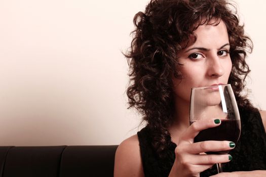 Portrait of a beautiful, latin Woman drinking red wine.