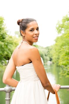 A young girl standing on a bridge.