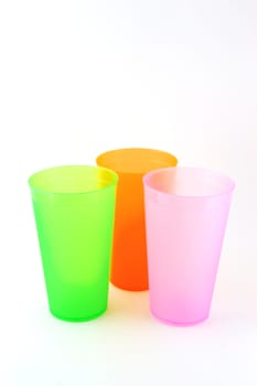 Green, orange and pink cups over white