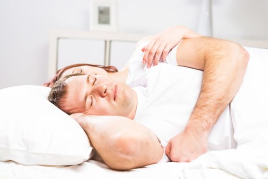 Mature man sleeping in bed with his wife