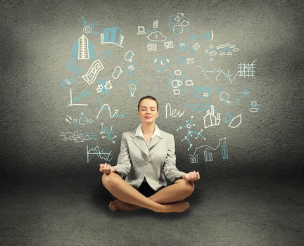 business woman meditating on floor, wall charts and diagrams are drawn