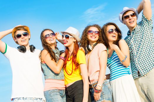 group of young people wearing sunglasses and hats hugging and standing in a row, spending time with friends