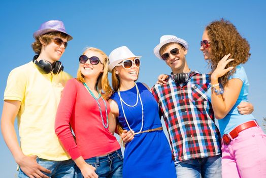 group of young people wearing sunglasses and hats hugging and standing in a row, spending time with friends