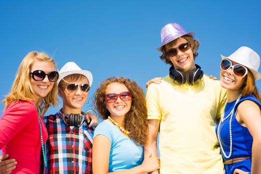 group of young people wearing sunglasses and hats hugging and standing in a row, spending time with friends