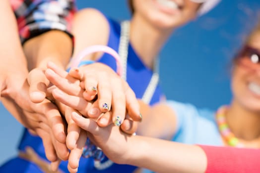 group of friends with arms folded in a column, teamwork