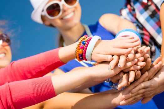 group of friends with arms folded in a column, teamwork