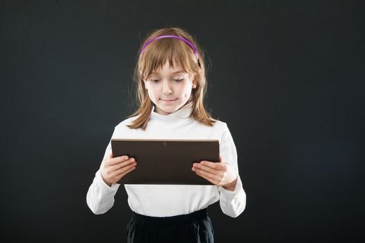 Portrait child with digital tablet on black background