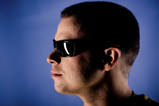 Portrait of man with glasses on blue background