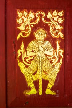 the detail of  thai gold painting pattern on ancient temple door,shallow focus,Lampang temple,Thailand