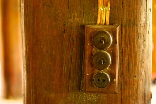 antique electronic switch on wooden house pillar,shallow focus