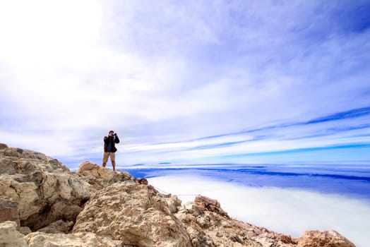 Man at  top of volcano Teide with blue sky. Teide is the highest volcano in Europe (Teide National Park, Tenerife, Canary islands, Spain).