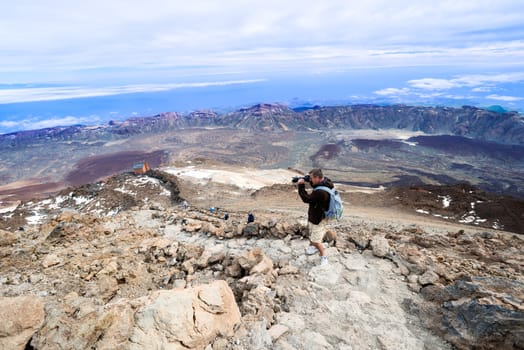 Man at  top of volcano Teide with blue sky. Teide is the highest volcano in Europe (Teide National Park, Tenerife, Canary islands, Spain).