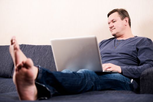 Man sitting on sofa with laptop
