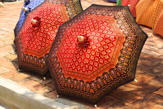 detail of thai traditional painted umbrella that made by silk fabric and wood structure with thai  pattern painting,shallow focus