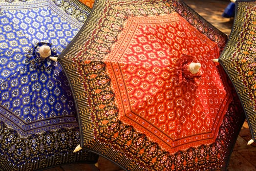 detail of thai traditional painted umbrella that made by silk fabric and wood structure with thai  pattern painting,shallow focus