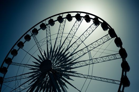 ferris wheel silhouette backlit by moonlight