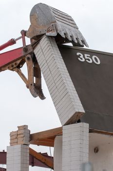 wreck excavator at work demolishing a building wall