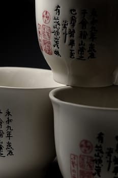 Three cups with chenese symbols, black background